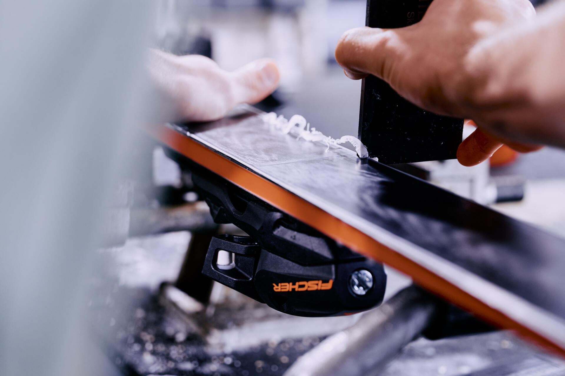 A person waxes a ski