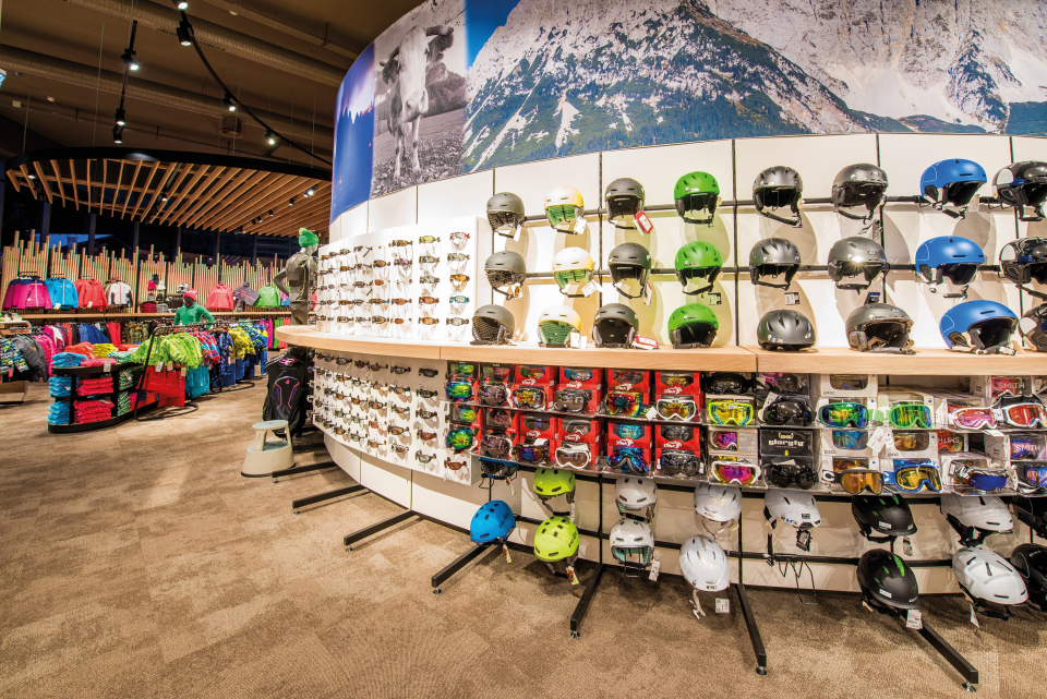 Shelf with ski helmets and ski goggles in the shop