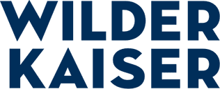 The bold dark blue text “Wilder Kaiser” appears on a transparent background. The simple, bold font conveys a sense of stability and presence.