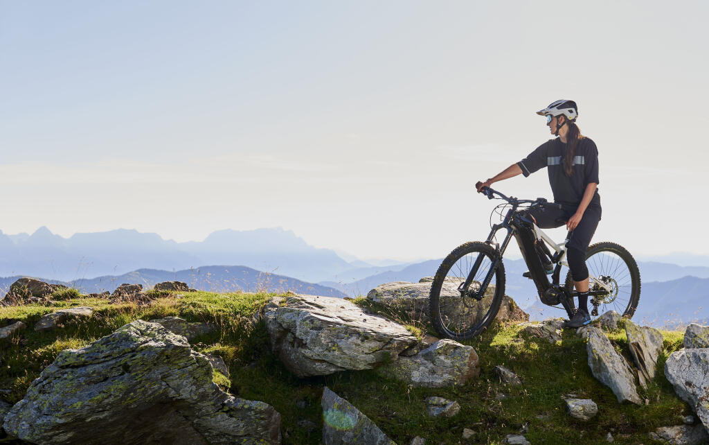 Eine Radfahrer blickt in die Berglandschaft