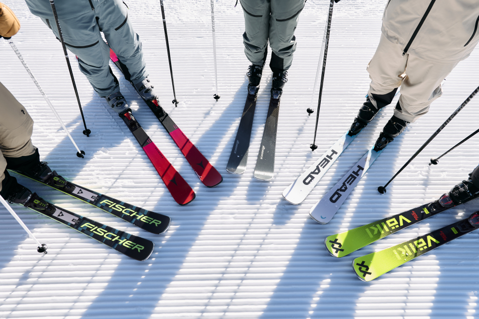 Blick auf die Skier verschiedener Marken von vier Skifahrern